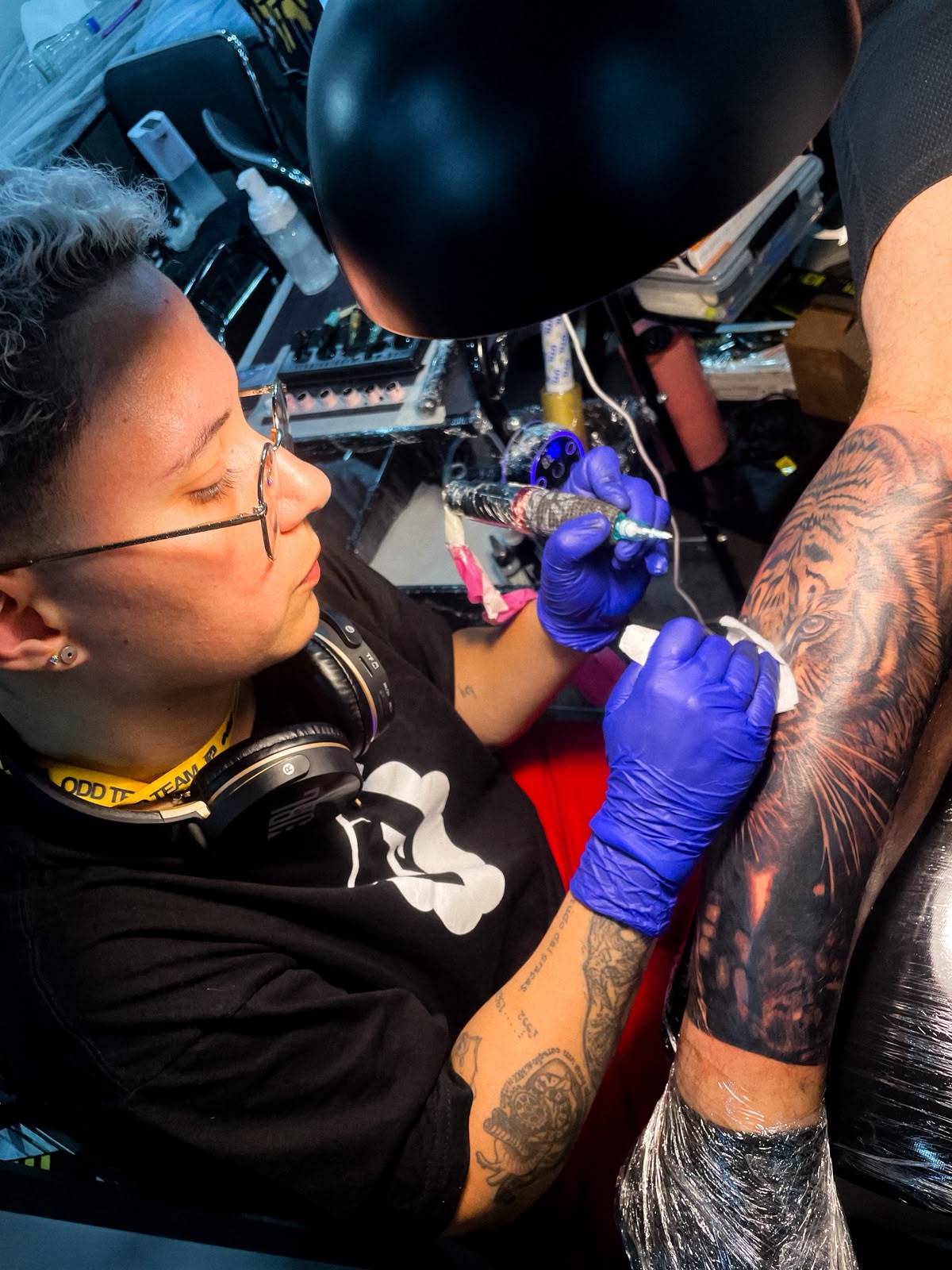Ellen em ação no estúdio, tatuando um tigre realista com foco e precisão