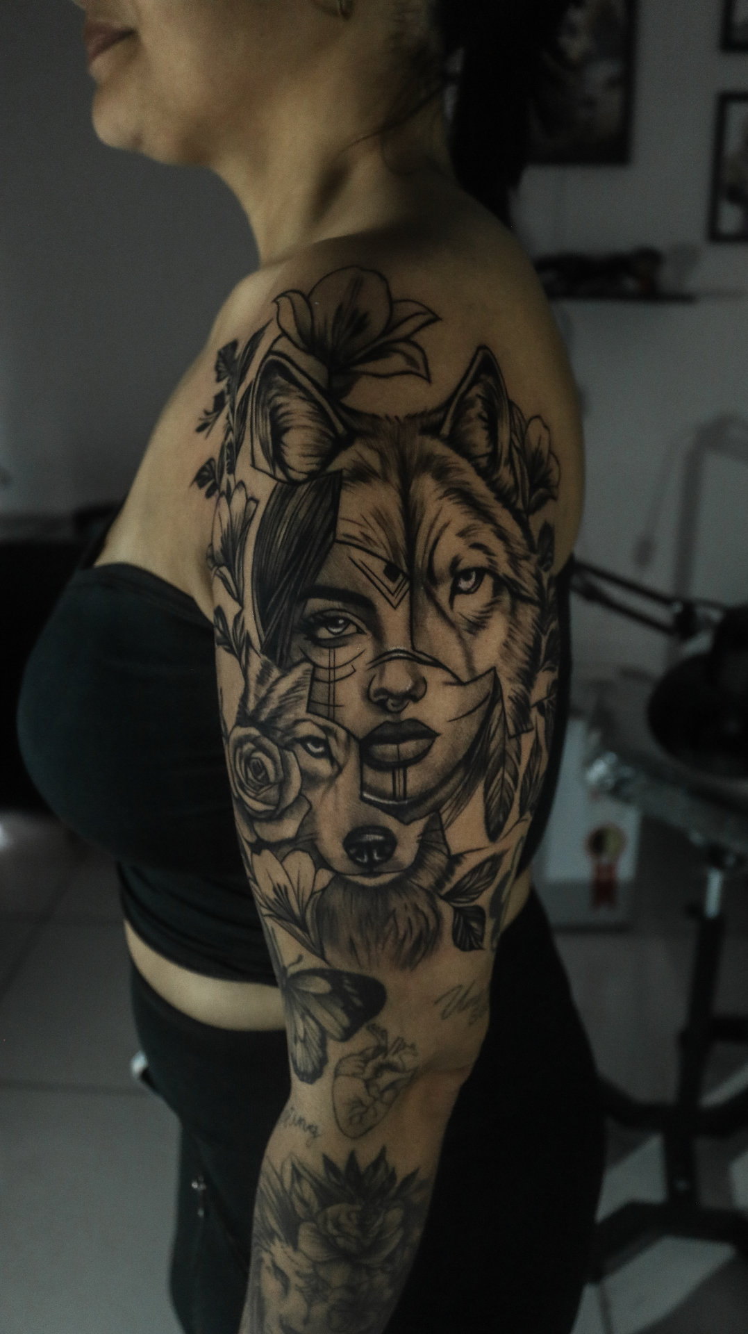 Braço fechado — mulher e lobo em realismo com flores